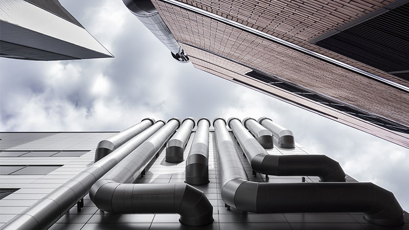 Low angle view of three skyscrapers ventilation pipes. Brick wall, venting pipeline or air duct.