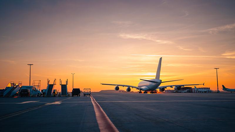Plane taking off at sunset
