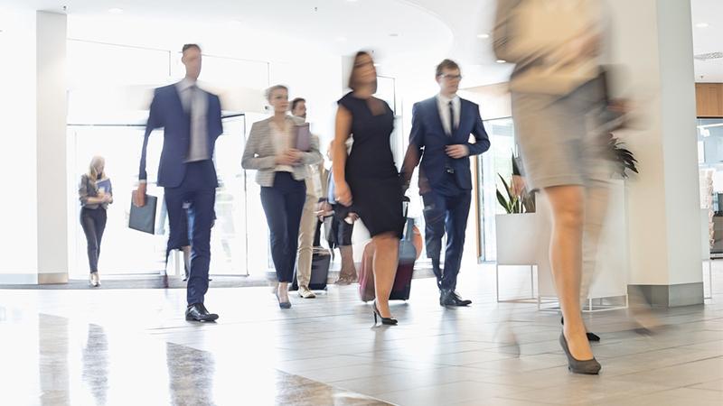 Blurred image of people walking in the office
