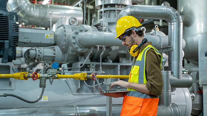 Ingénieur avec ordinateur portable travaillant dans une centrale thermique