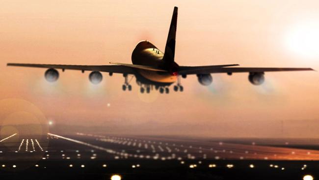 Airplane taking off at sunset