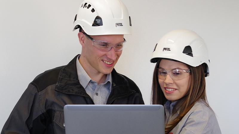 Man and woman in hard hats with laptop